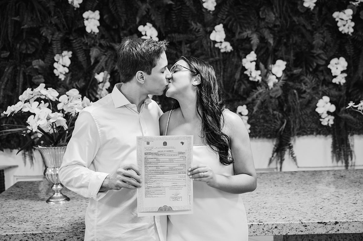 Noivos segurando a certidão de casados