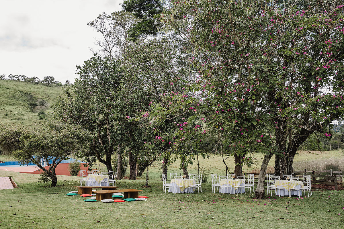 cenário com mesas em baixo de arvores para festa infantil