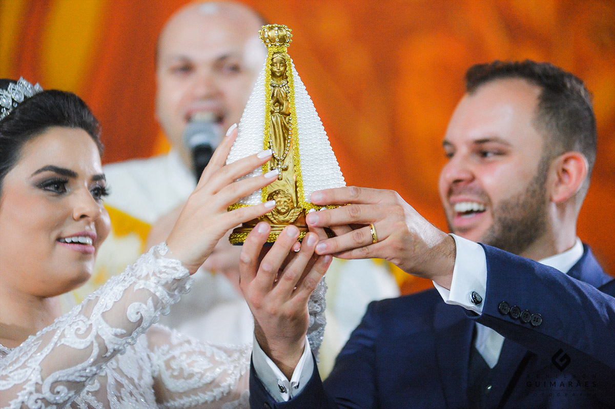 os noivos erguendo a santa para todos verem
