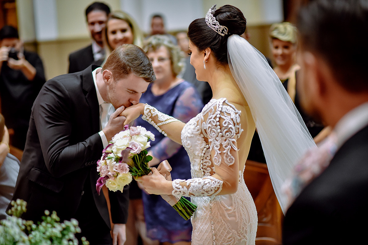 O noivo beijando a mão da noiva