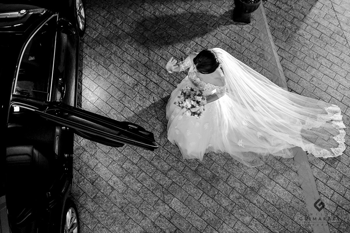 A noiva entrando no carro a caminho da igreja