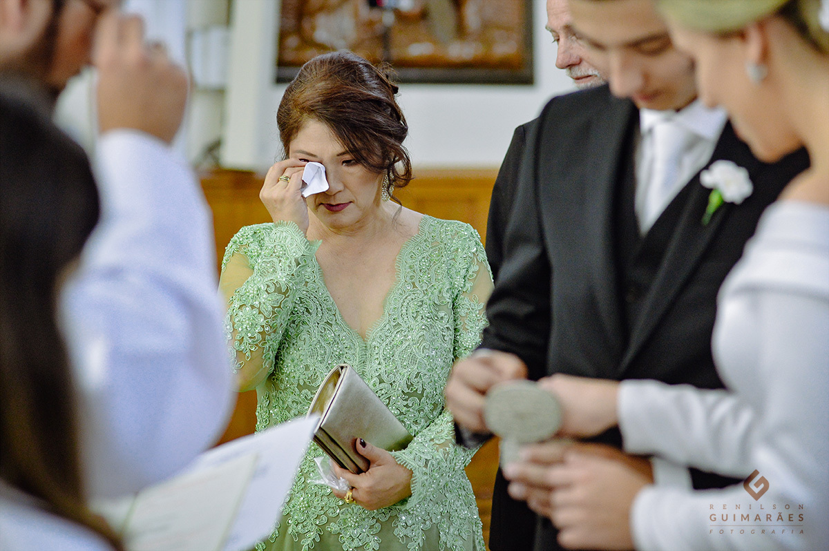 A mãe do noivo limpando as lágrimas