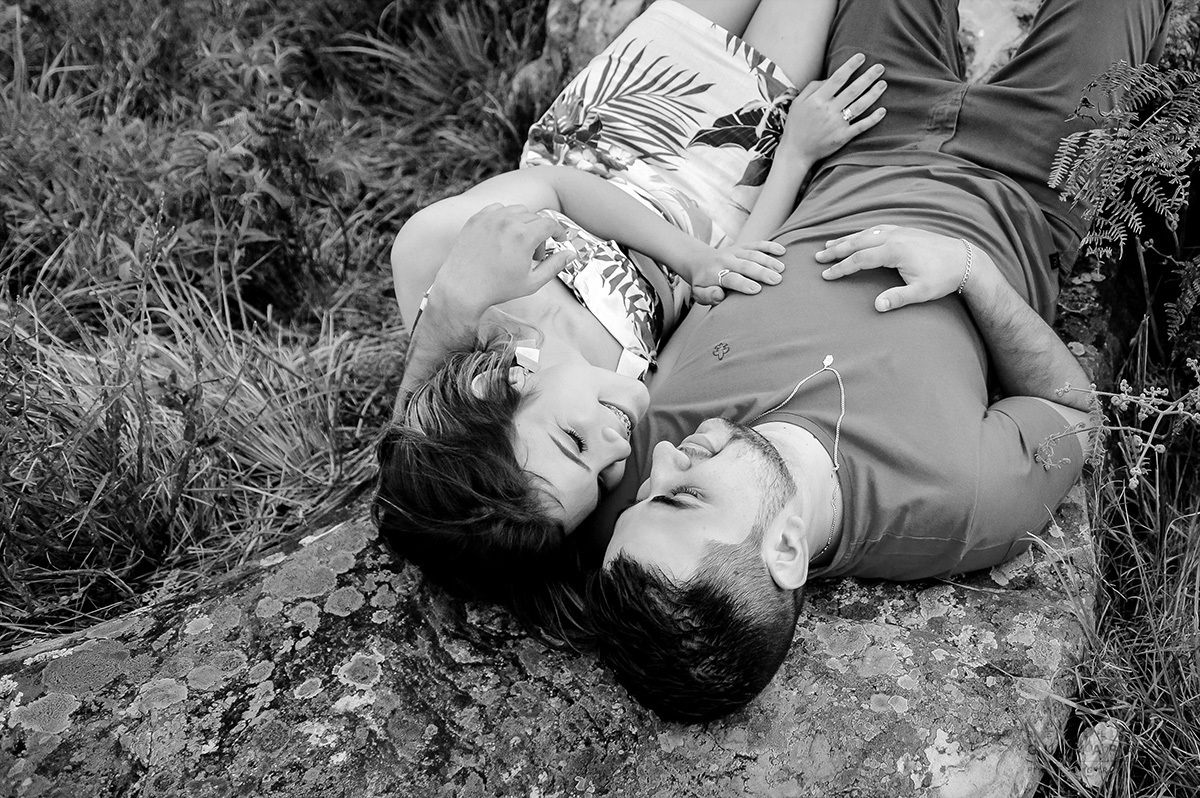 Os noivos deitados juntinhos na pedra