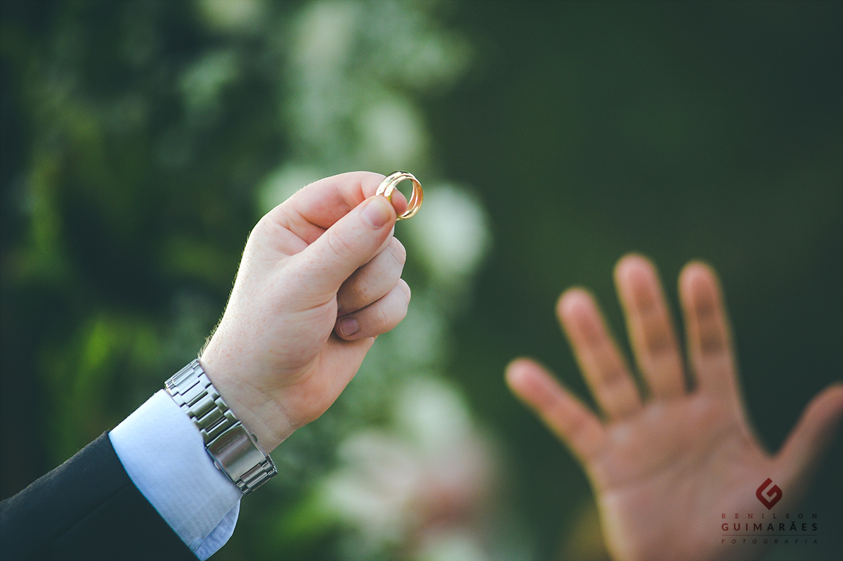 As alianças dos noivos na mão do pastor