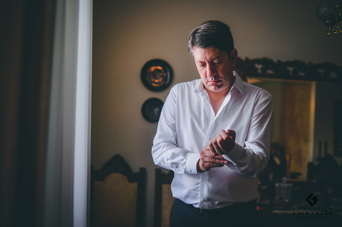 O noivo abotoando a camisa
