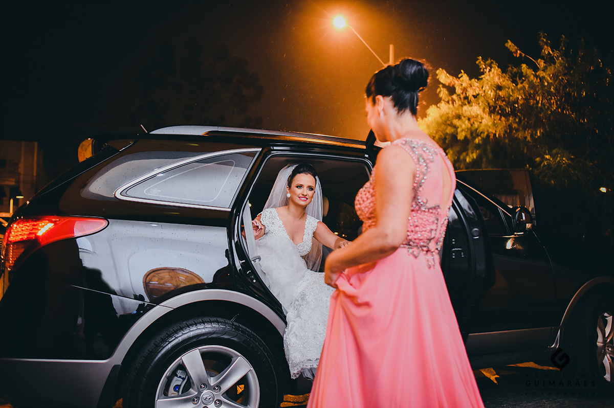 A noiva saindo do carro com a ajuda da sua mãe