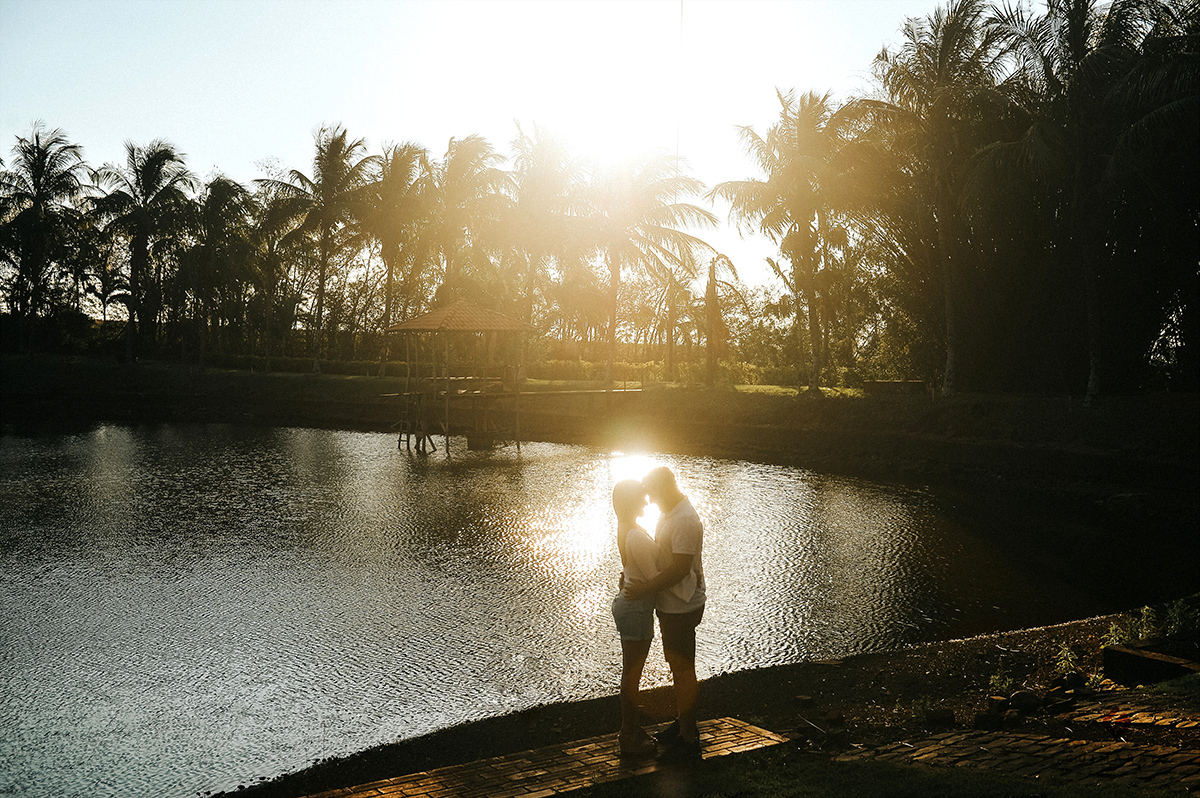 Noivos a beira do lago com um lindo por do sol