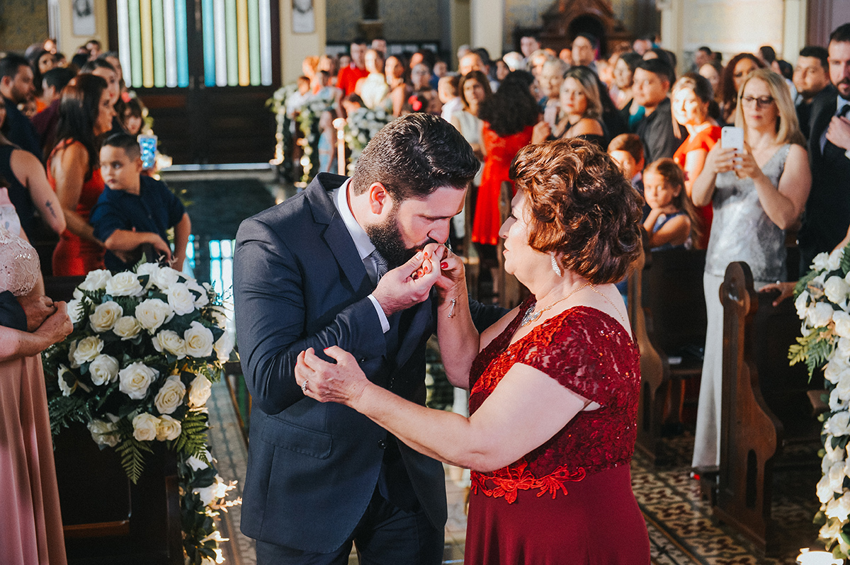 O noivo beijando a mão da sua mãe