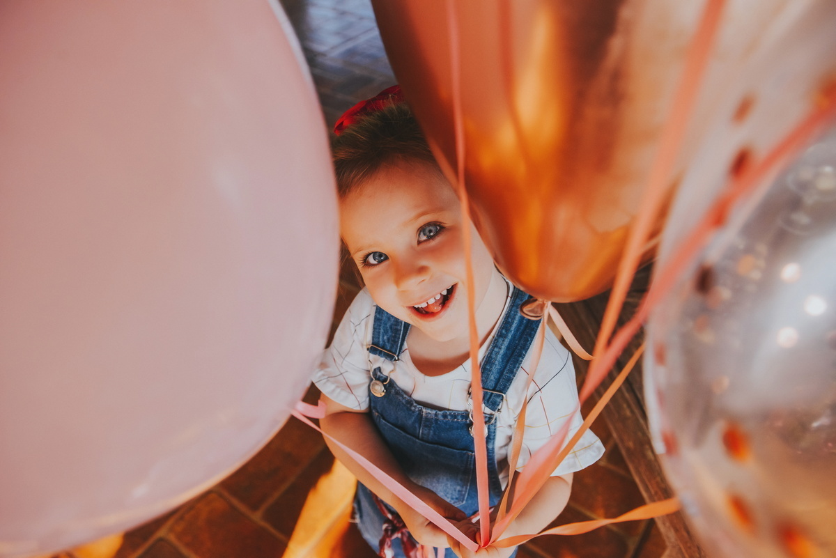 A Clara com vários balões coloridos