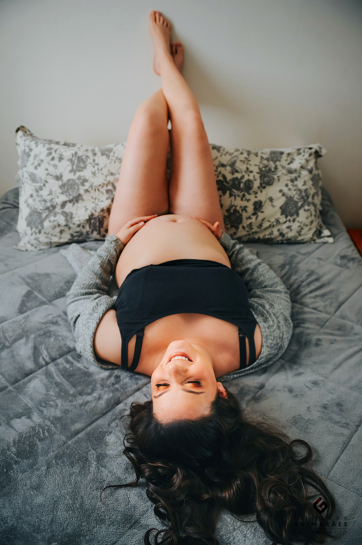 A gestante deitada na cama de pernas para o ar