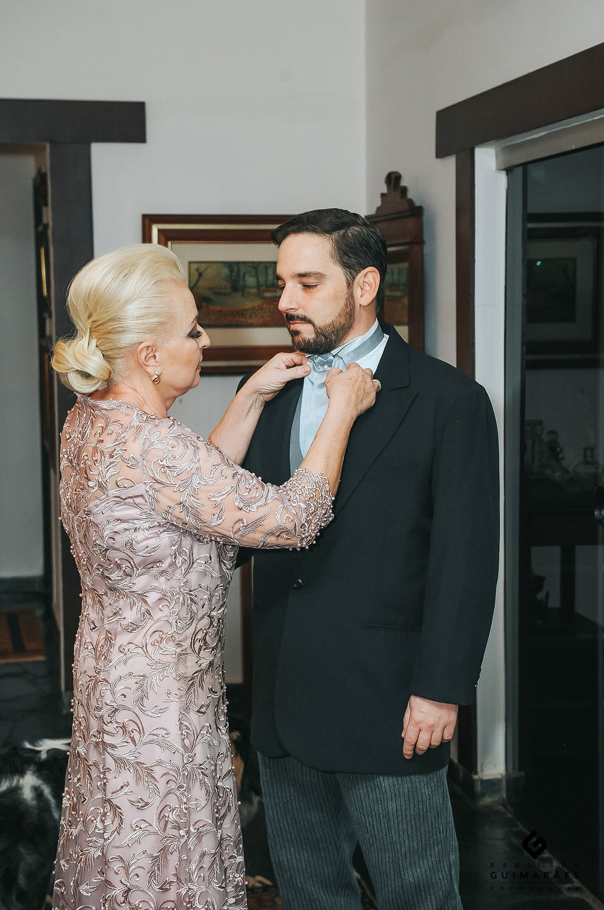 A mãe do noivo arrumando a gravata do noivo