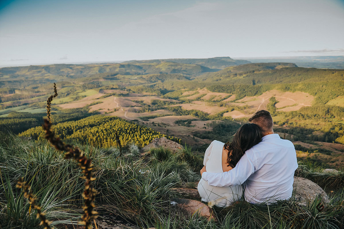 Noivos abraçados olhando o horizonte