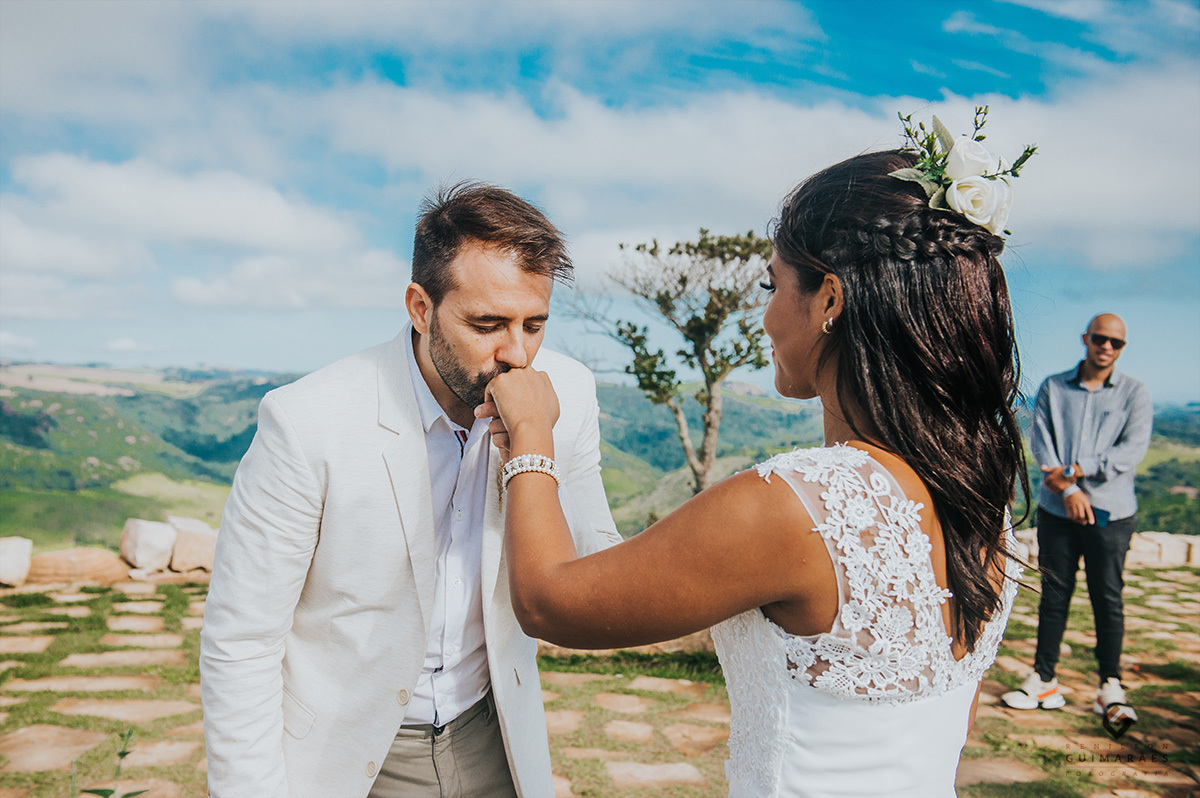 Noivo beijando a aliança da noiva