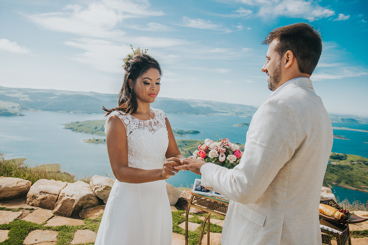 Noiva colocando a aliança no noivo