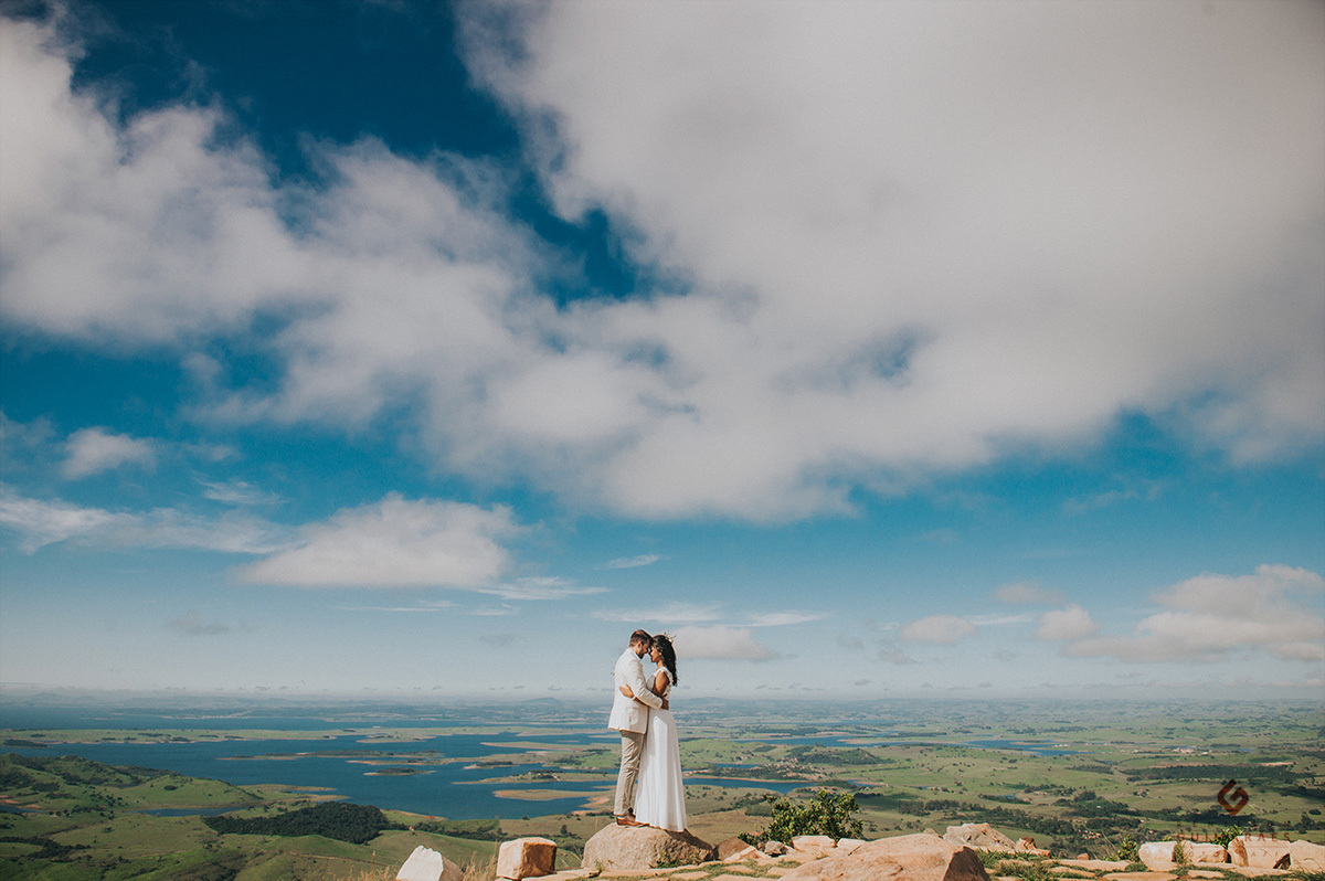 Os noivos abraçados no alto da montanha