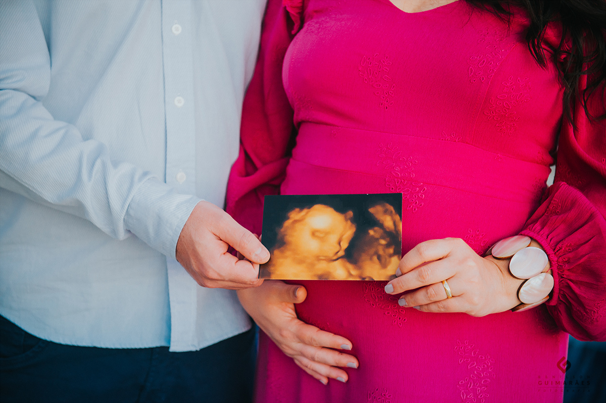 Pai e mãe segurando a foto do ultrassom do bebê