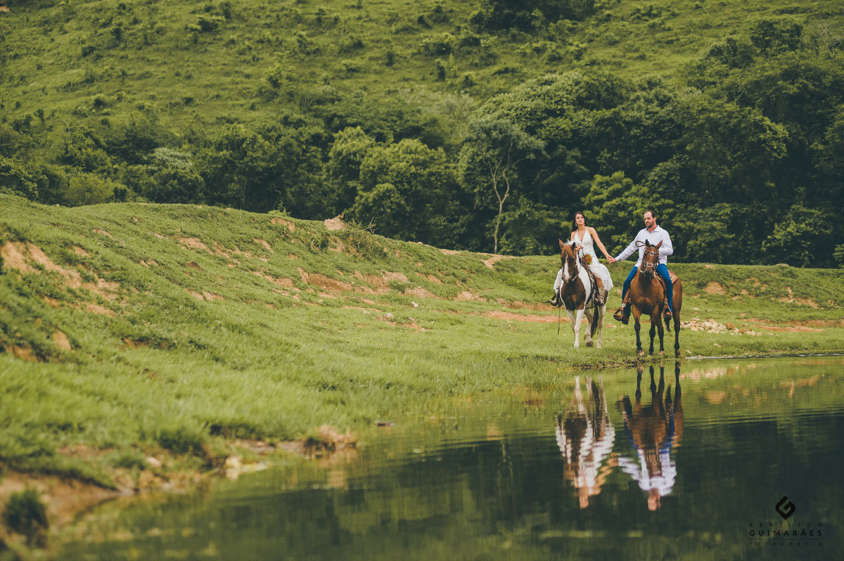Noivos com os cavalos na beira do lago