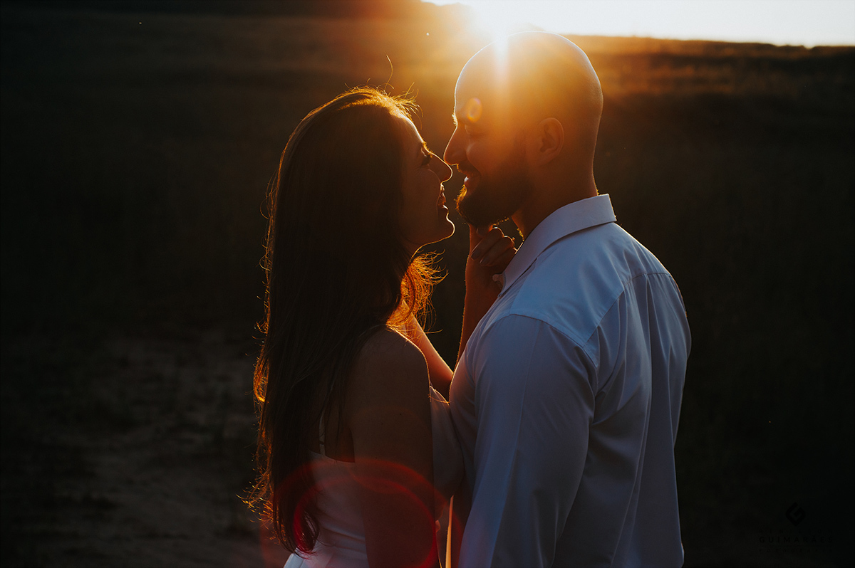 Noivos bem juntinhos no por do sol
