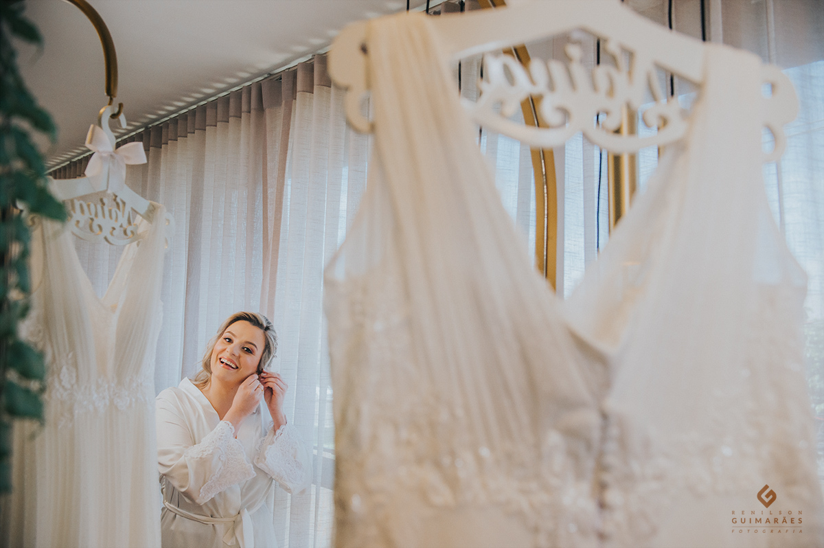 A noiva colocando o brinco 