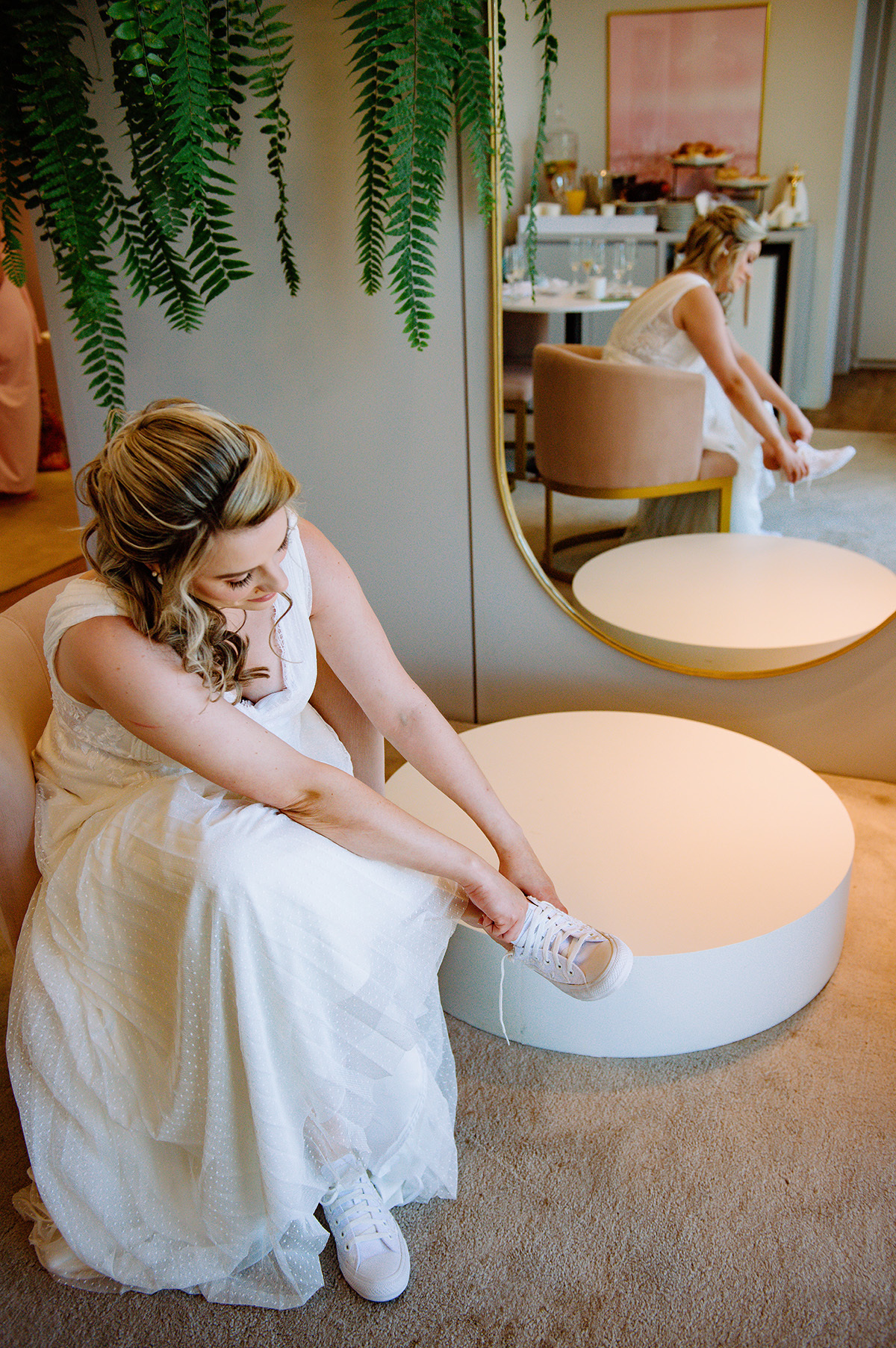 A noiva colocando o tenis branco para o seu casamento