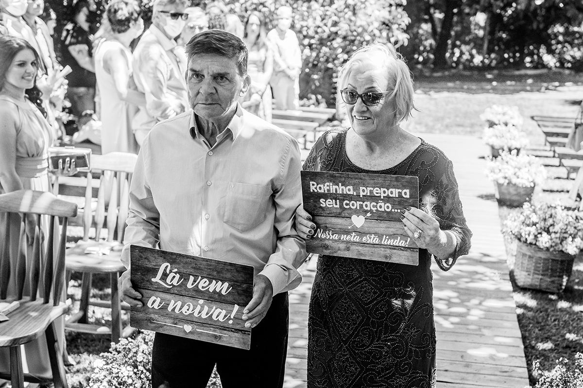 Avós da noiva entrando com plaquinhas no casamento
