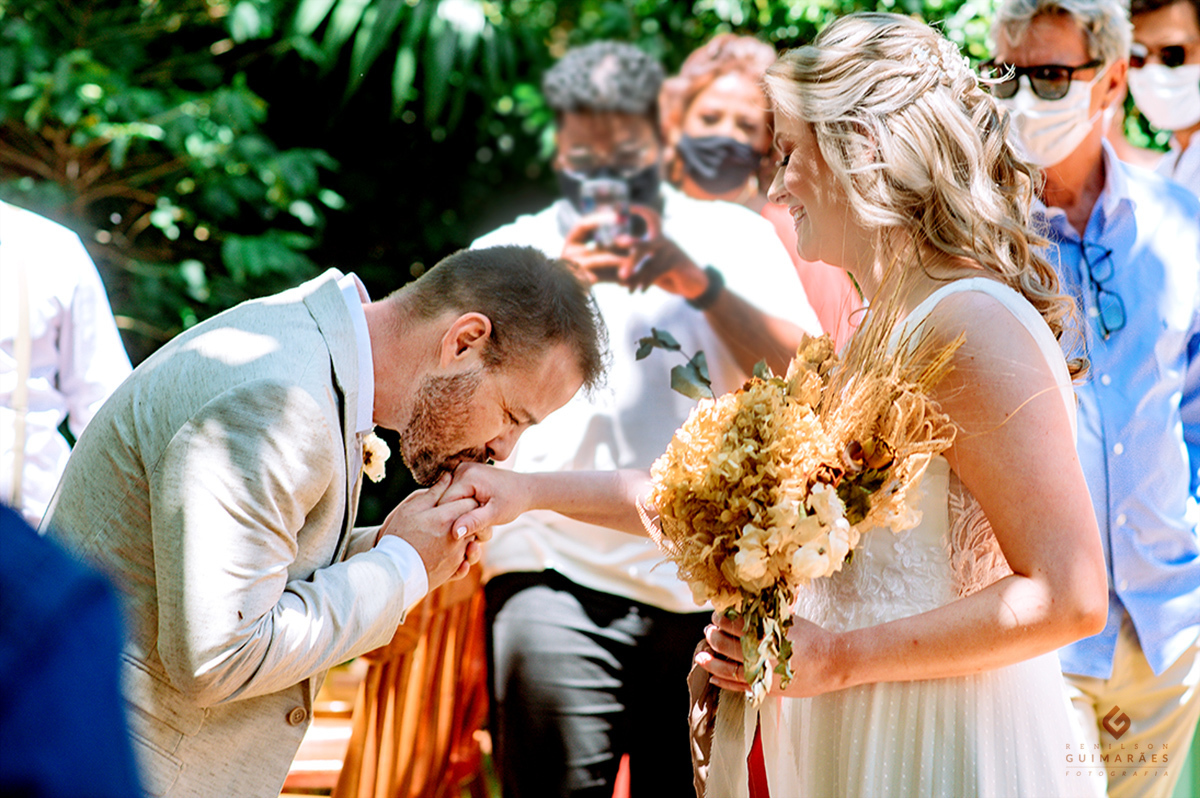 O noivo beijando a mão da noiva
