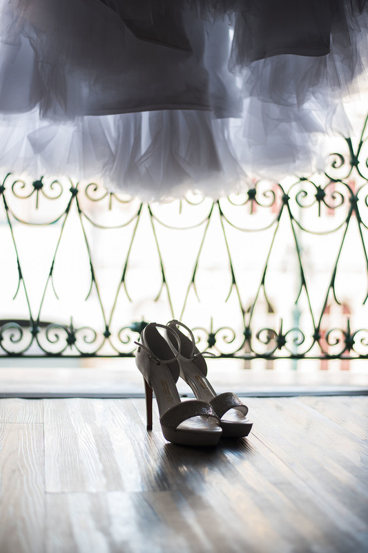 Giselle Solyom fotografa sapatos e vestido de noiva na janela do Hotel Johnscher.