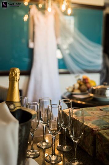 Vestido de noiva iluminado no hotel Bourbon Curitiba, com Giselle Solyom fotógrafa de Casamento e taças de champagne.
