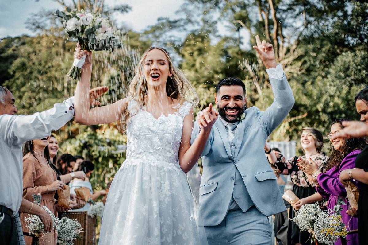 saída dos noivos da cerimônia com chuva de arroz