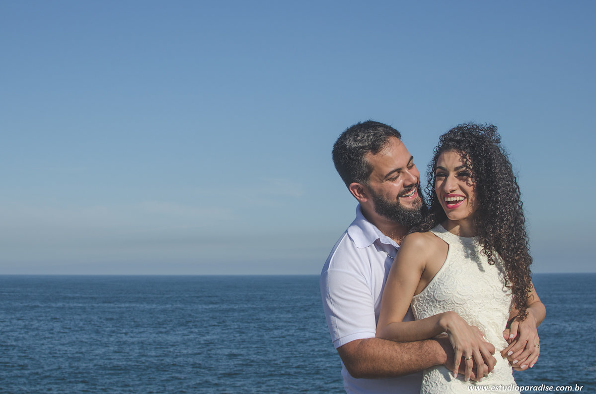 ensaio de casal pre casamento na praia com o mar ao fundo