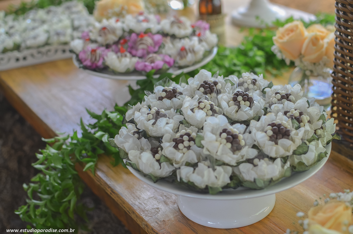 Decoração e docinhos da mesa do bolo na recepção do casamento ao ar livre de dia em Chácara Minas Gerais