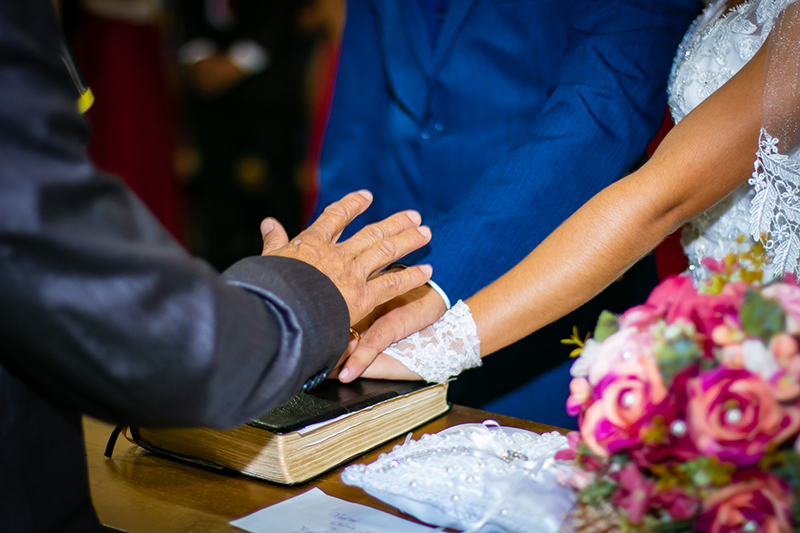 maos dos noivos sobre a biblia e pastor abencoando o casal colocando a sua mao sobre a mãos deles casamento colider sinop itauba guaranta mato grosso dominik fotografia album