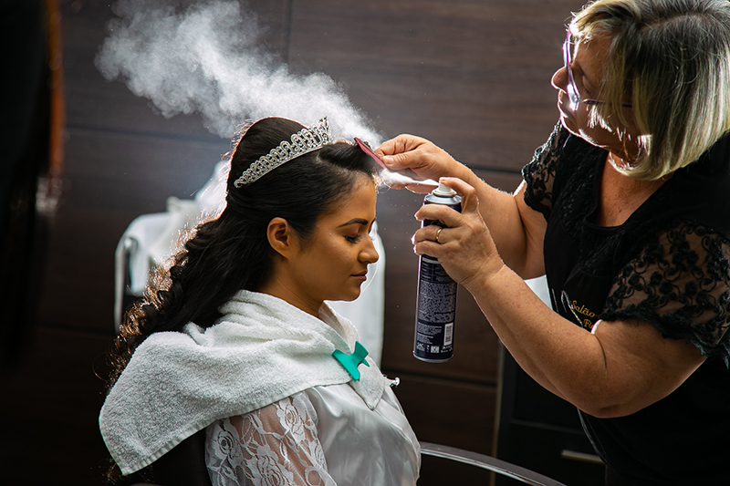 cabeleireira arrumando cabelo da noiva aplicando spray noiva sentada maquiada colider sinop itauba guaranta mato grosso dominik fotografia album