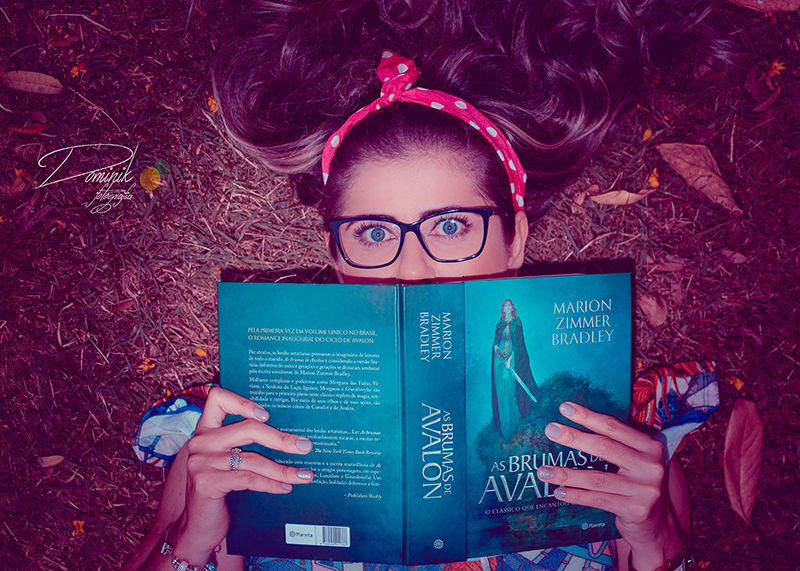 ensaio divertido criativo deitada no chão e com livro aberto sob o rosto ela esta usando oculos e laços no cabelos sinop vera claudia itauba terra nova do norte santa camerm sorriso mato grosso dominik fotografia