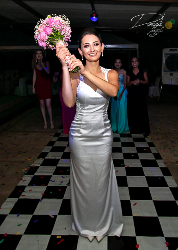 noiva em primeio plano com buque nas maos pronta para jogar para as madrinhas ao fundo capela casamento celebração terra nova itauba matupá sinop sorriso guaranta  mato grosso fotografia criativa dominik lago de matupa