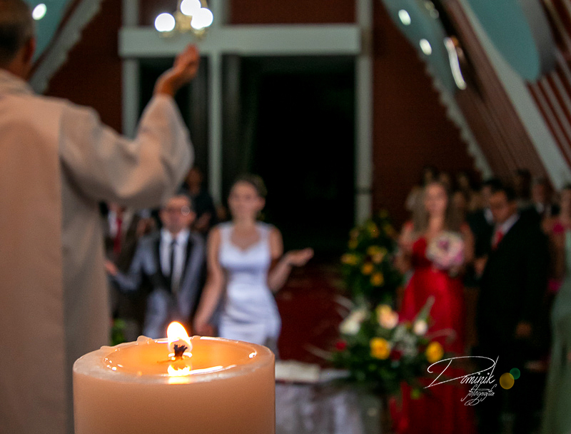 vela em primeiro plano casal de noivos ao fundo capela lago de matupa