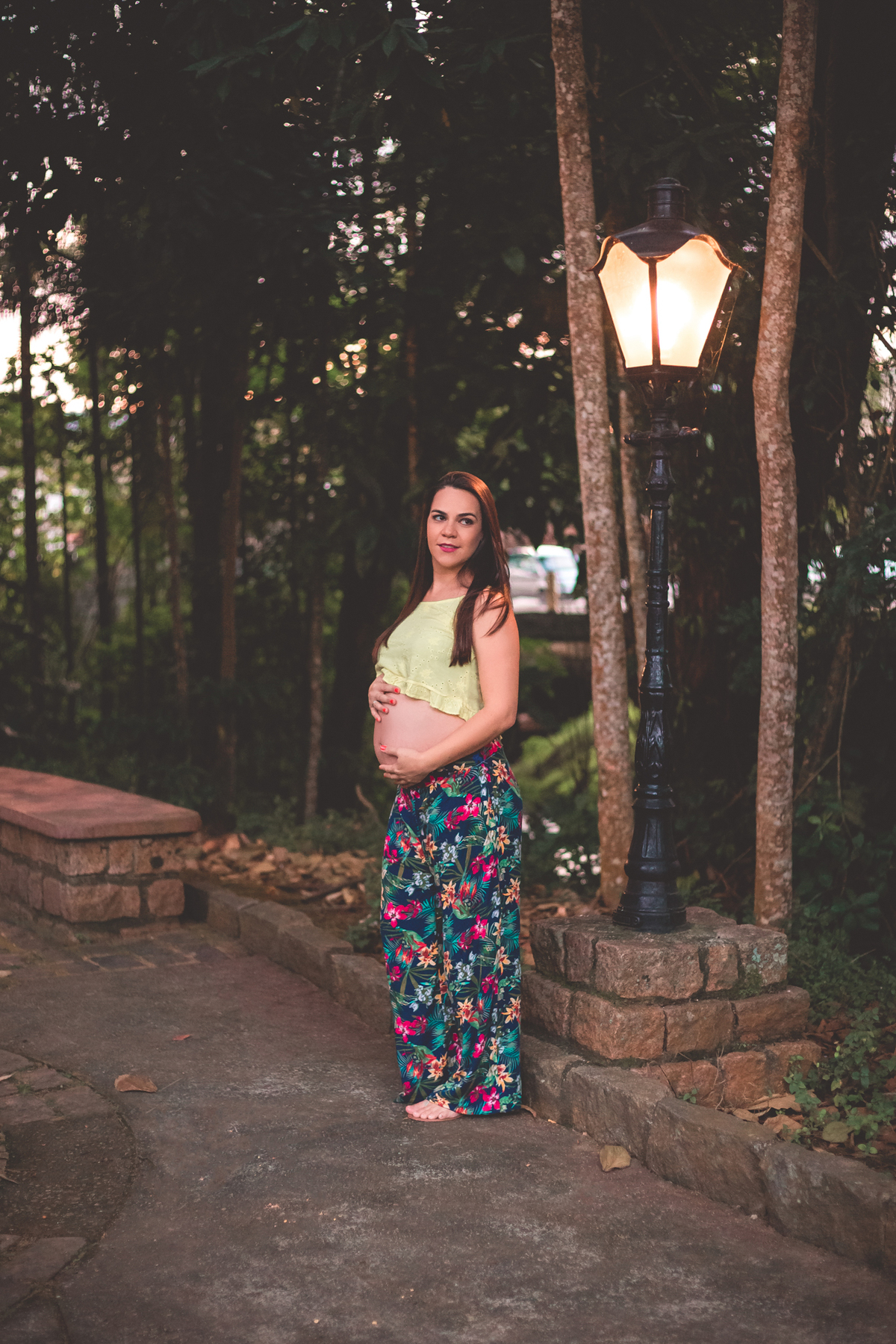 gestante com as mãos na barriga olhando para o lado em um ensaio na brasital em são roque sp