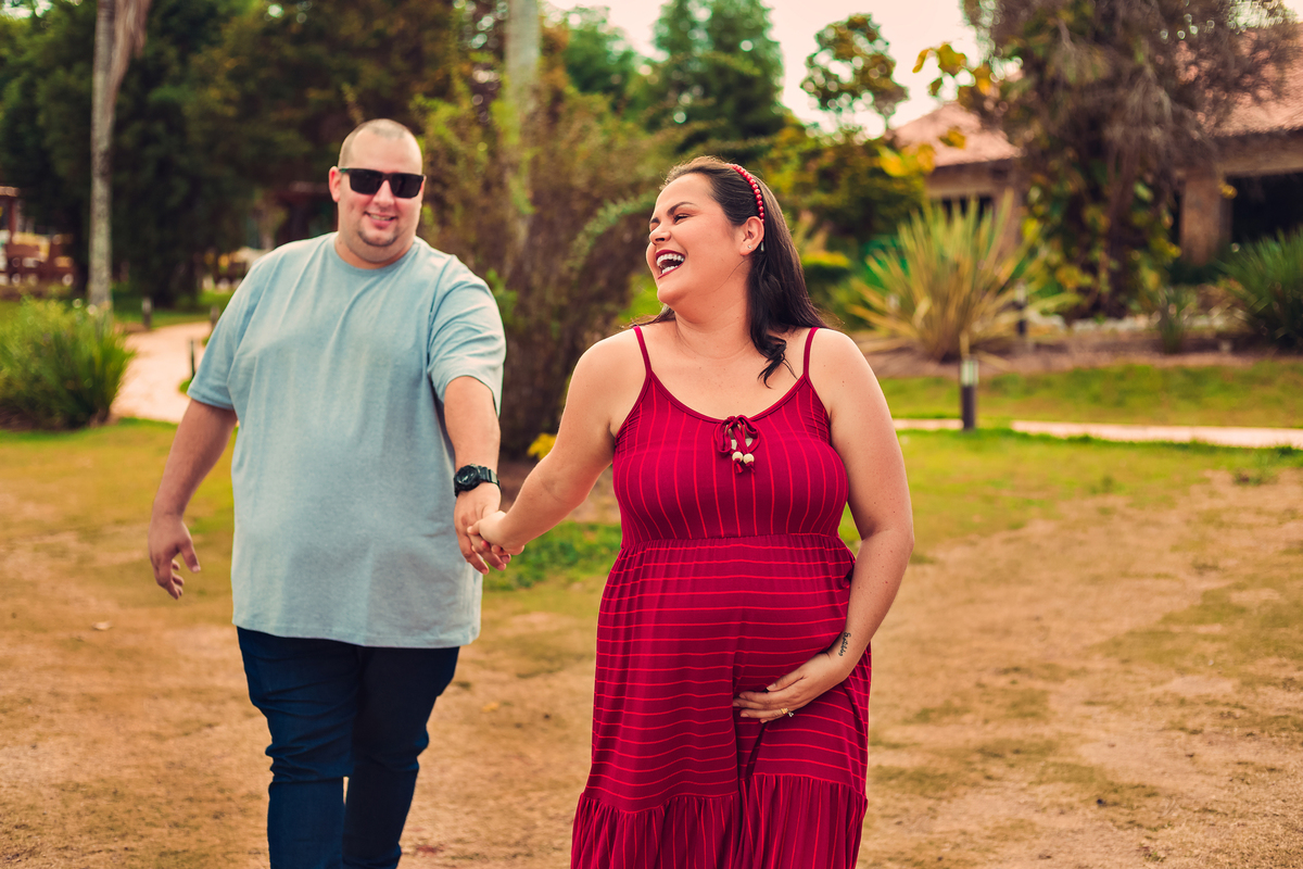casal correndo de mãos dadas e sorrindo em ensaio gestante no don patto em são roque sp