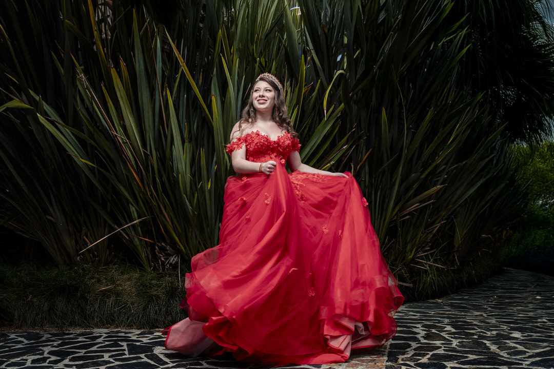 Retrato artístico de quinceañera en un escenario histórico.