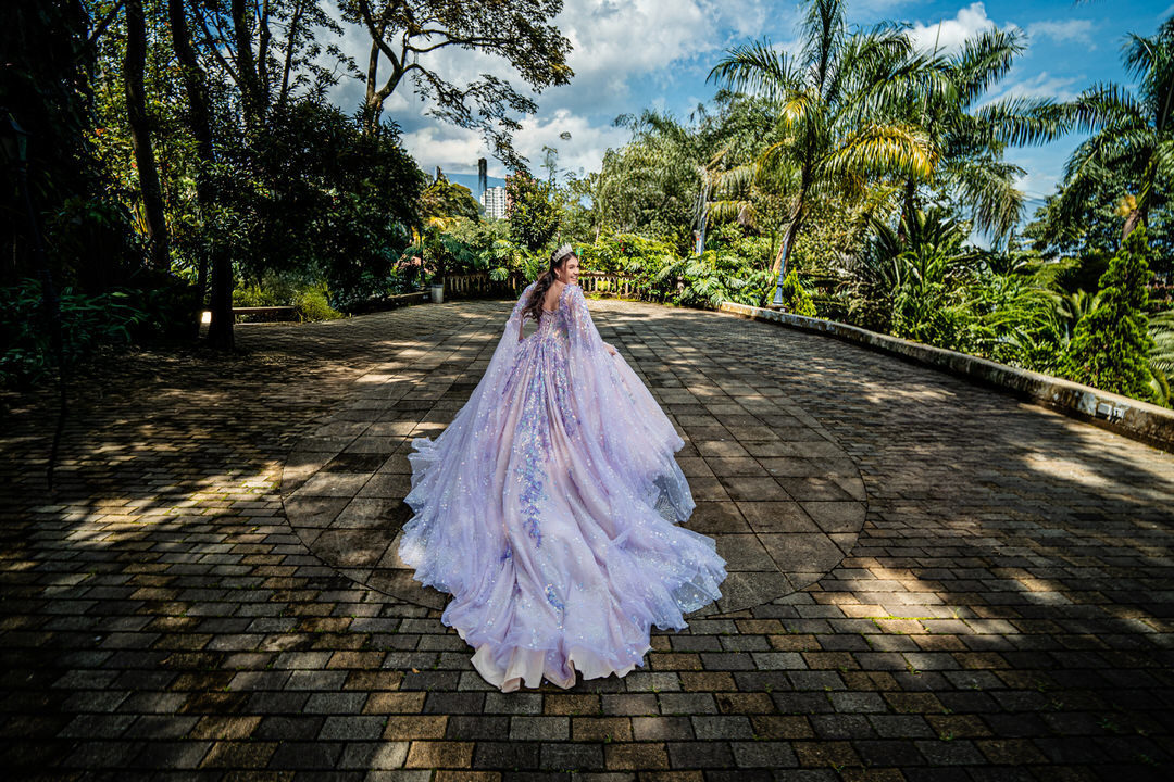 Sesión de quinceañera rodeada de jardines y arquitectura europea.
