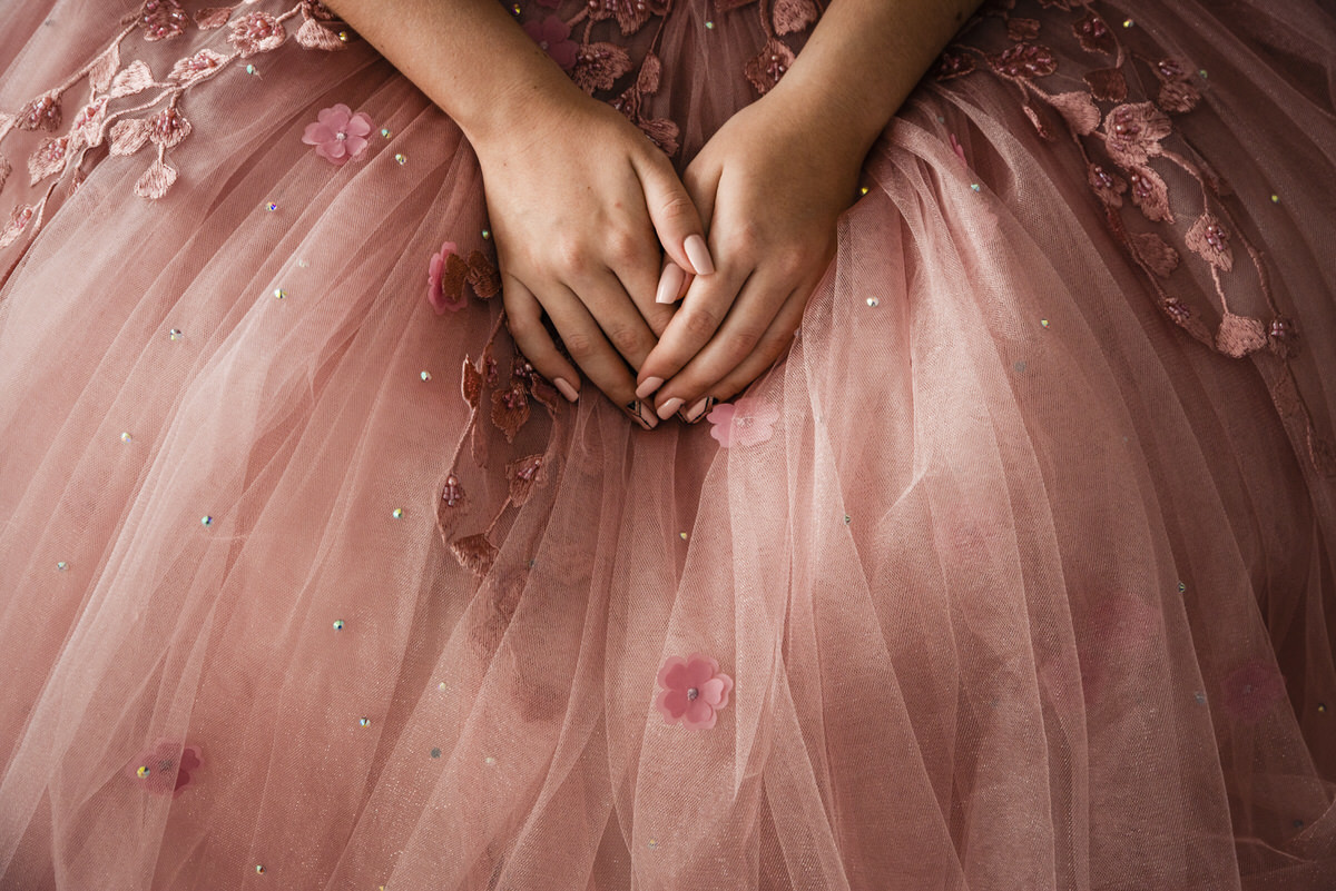 Manos de Ximena sobre el vestido de sus 15 años