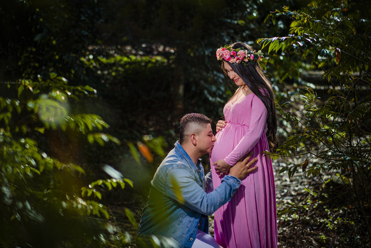 Esposo dándole un besito a la barriga de Viviana en su sesión de maternidad