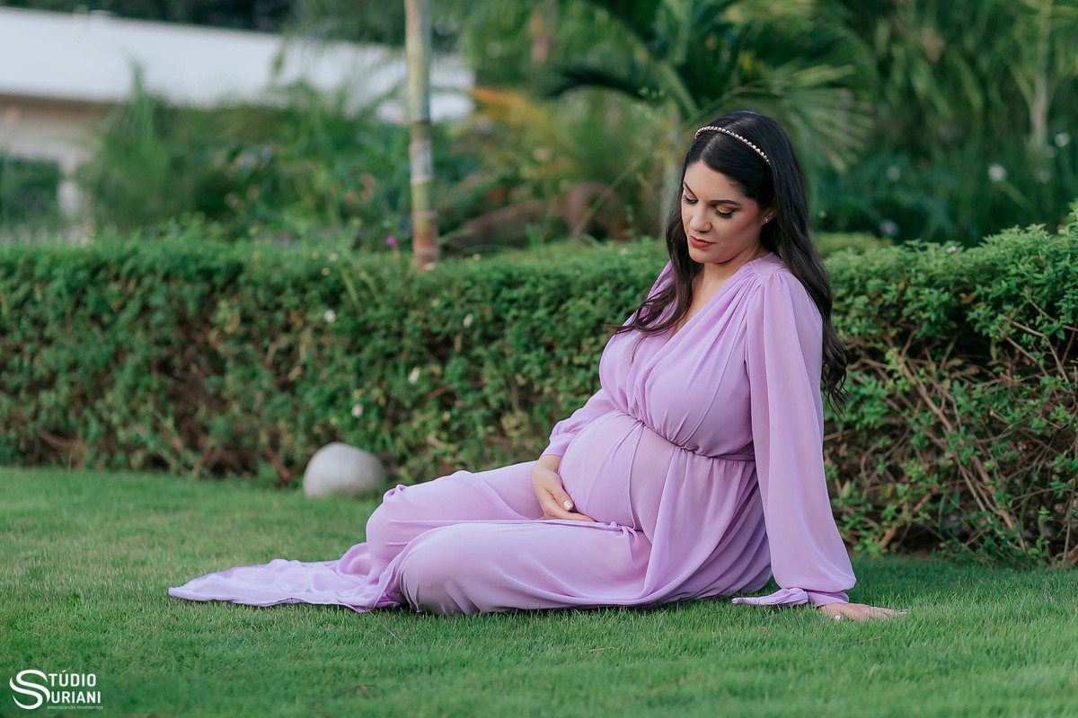 sentado no chão com barrigão e jardim verde indo e local calmo