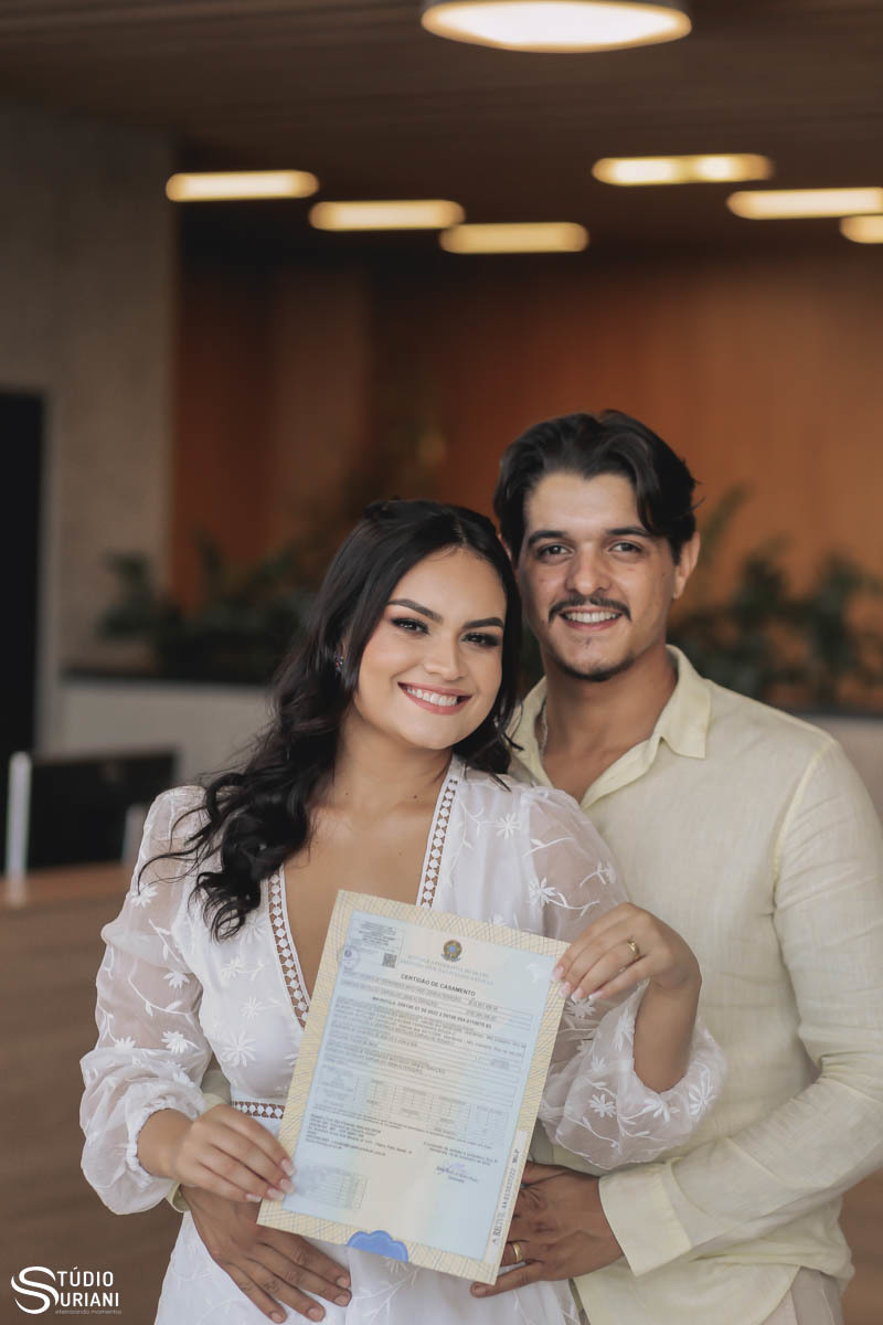 Foto dos noivos segurando certificado de casamento