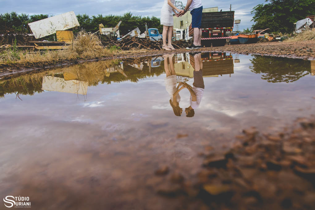 reflexo dos noivos em poça de agua no ferro felho