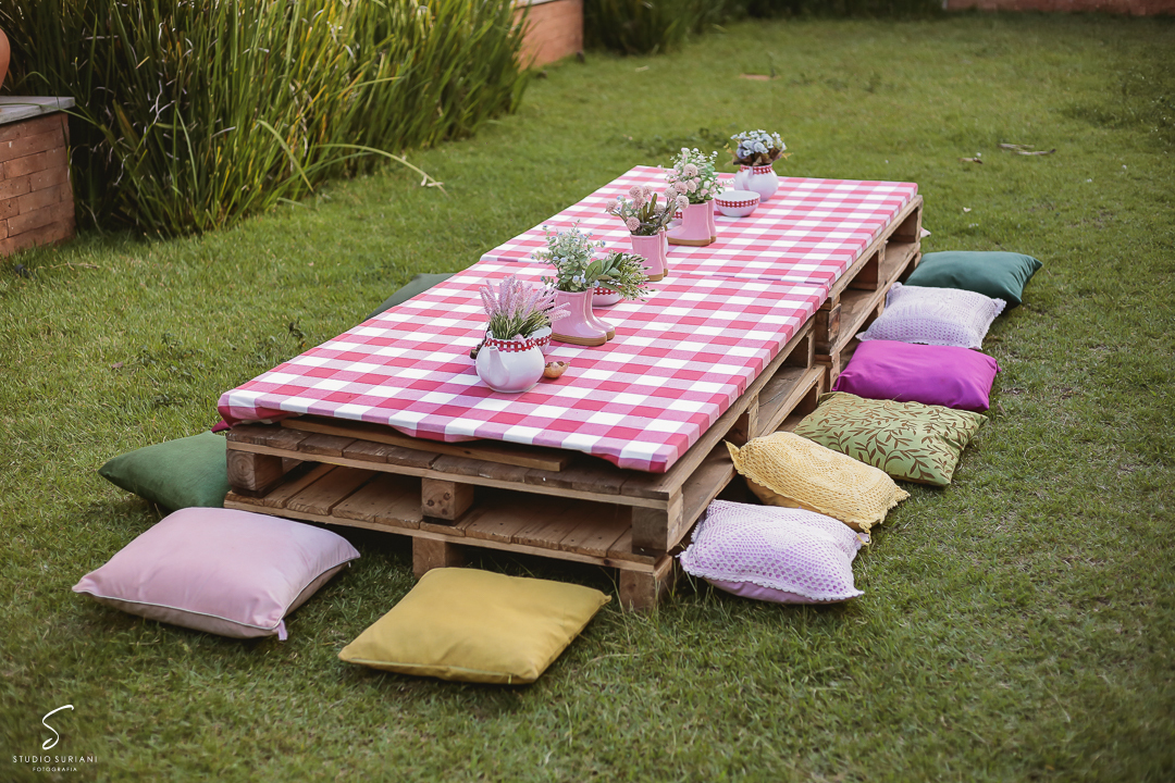 Mesa de piquenique para festa de aniversário com almofadas para as crianças brincarem   
