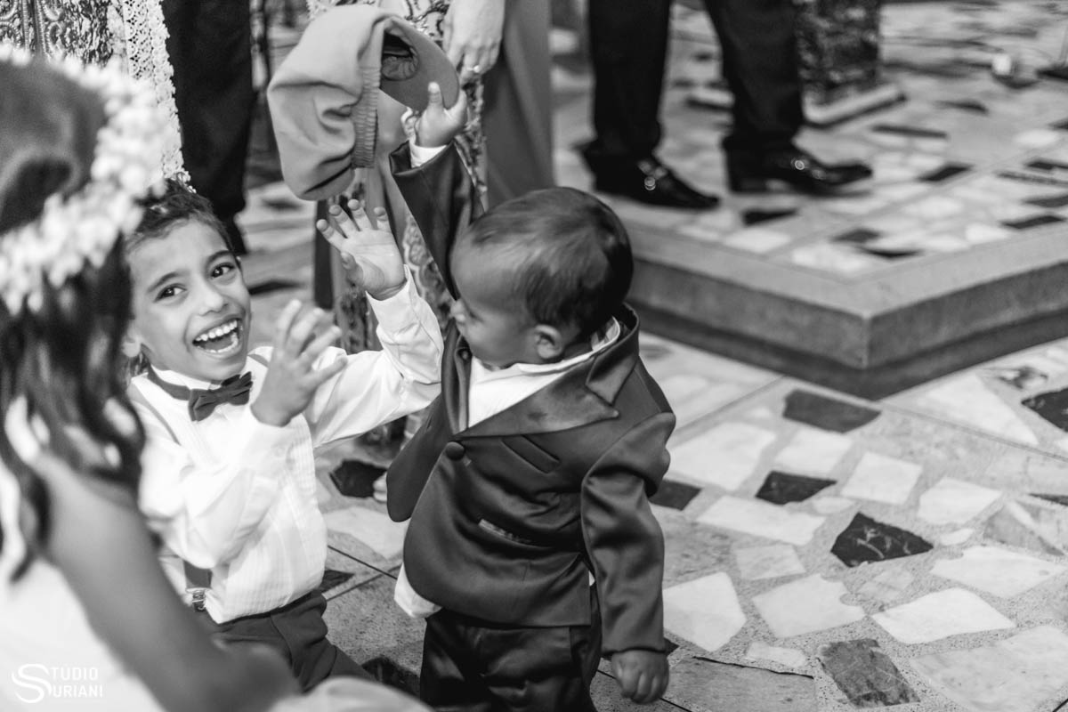 Filho dos noivos fazendo bagunça na igreja durante o casamento