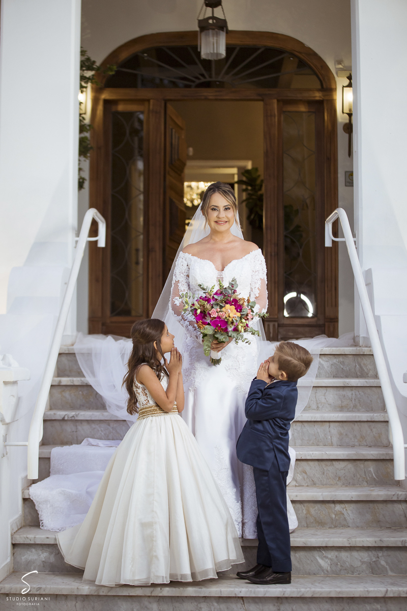 Filhos olhando para a noiva assustando com sua beleza 