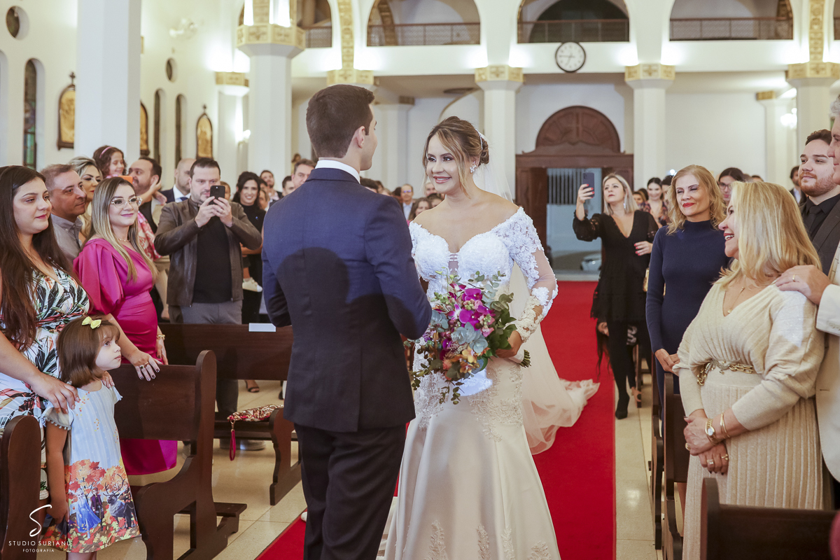 Primeiro olhar a noiva com o noivo no dia do casamento no corredor da igreja 
