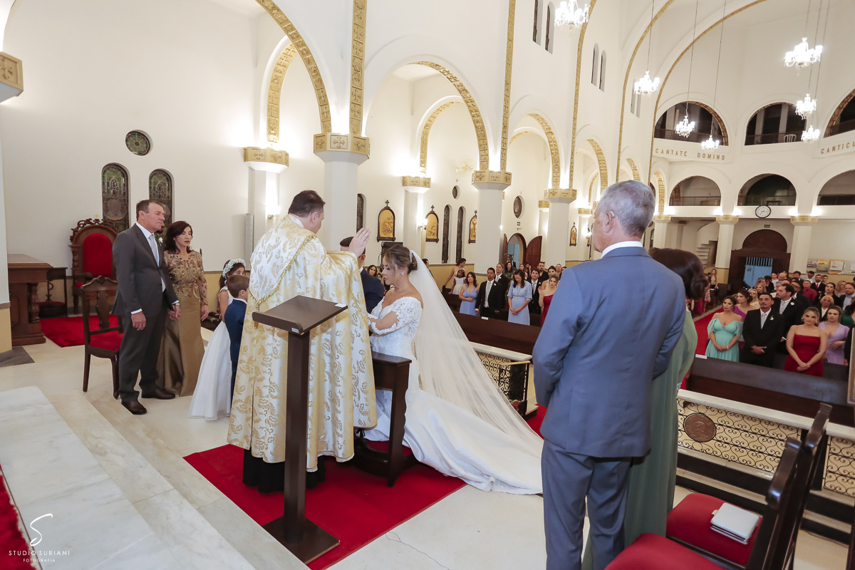 Padre abençoa o noivo e a noiva com fertilidade e que seus filhos sejam educados na fé católica 